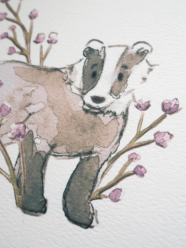 Close up watercolour painting of a badger surrounded by lilac flowers, painted by Carla Gebhard.