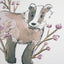 Close up watercolour painting of a badger surrounded by lilac flowers, painted by Carla Gebhard.