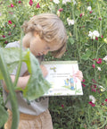 A little boy holding 'Lucy and Liam's Tiny Adventure' Children's Book.