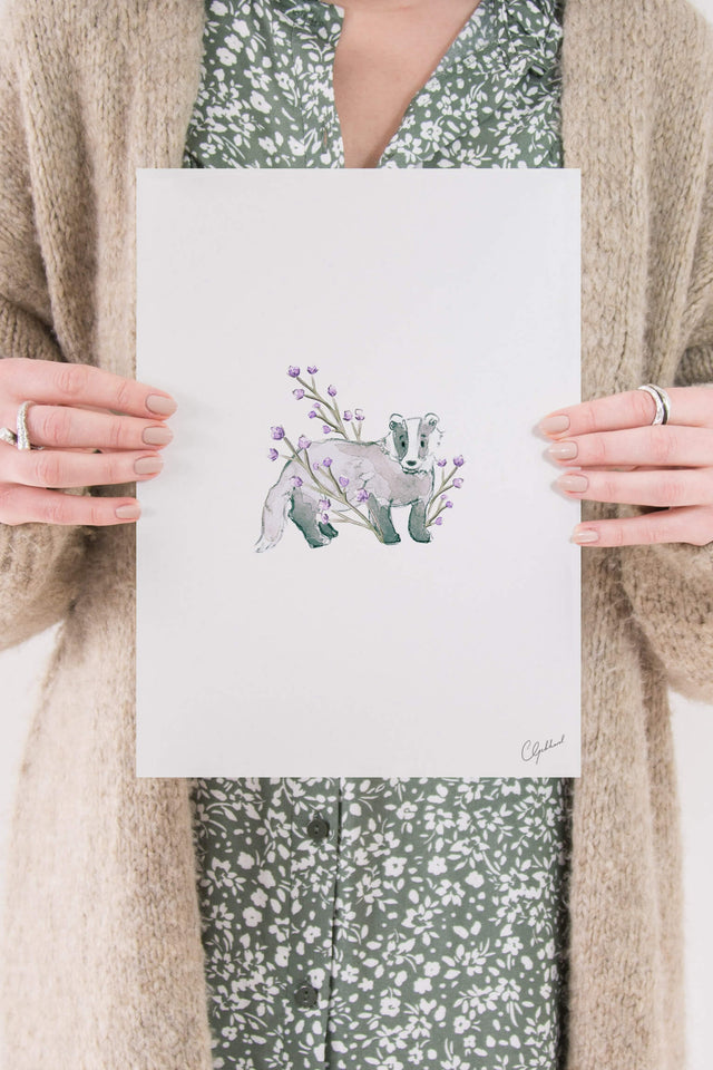 Floral print of a badger surrounded by lilac flowers, painted by Carla Gebhard.