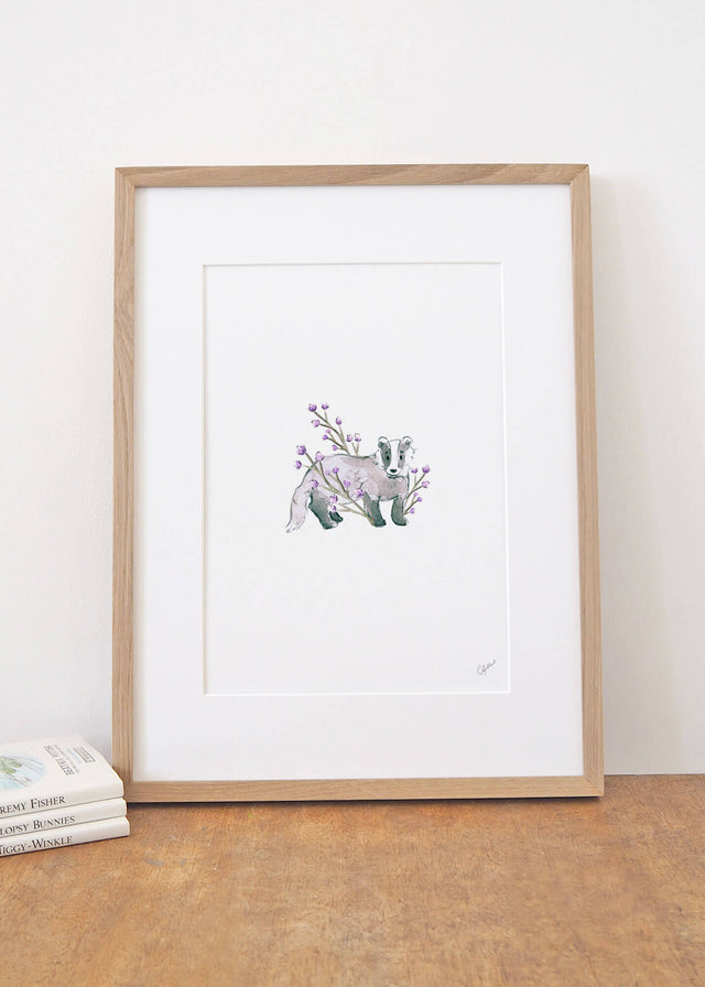Framed art print of a badger surrounded by lilac flowers, painted by Carla Gebhard.